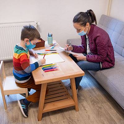 woman taking notes while child is drawing