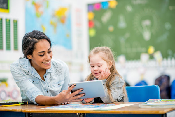 teacher working with a special education student on an tablet